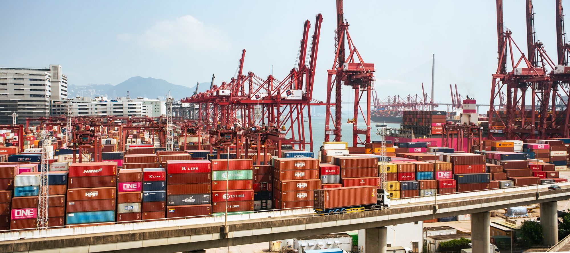 Container cranes and freight at a Hong Kong port, illustrating the cross-border movement affected by export controls.