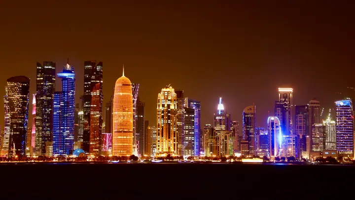 Doha skyline across the waterfront at night, illustrating long-term Gulf political and economic change.